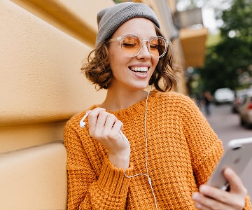The smiling girl with smartphone and headphones